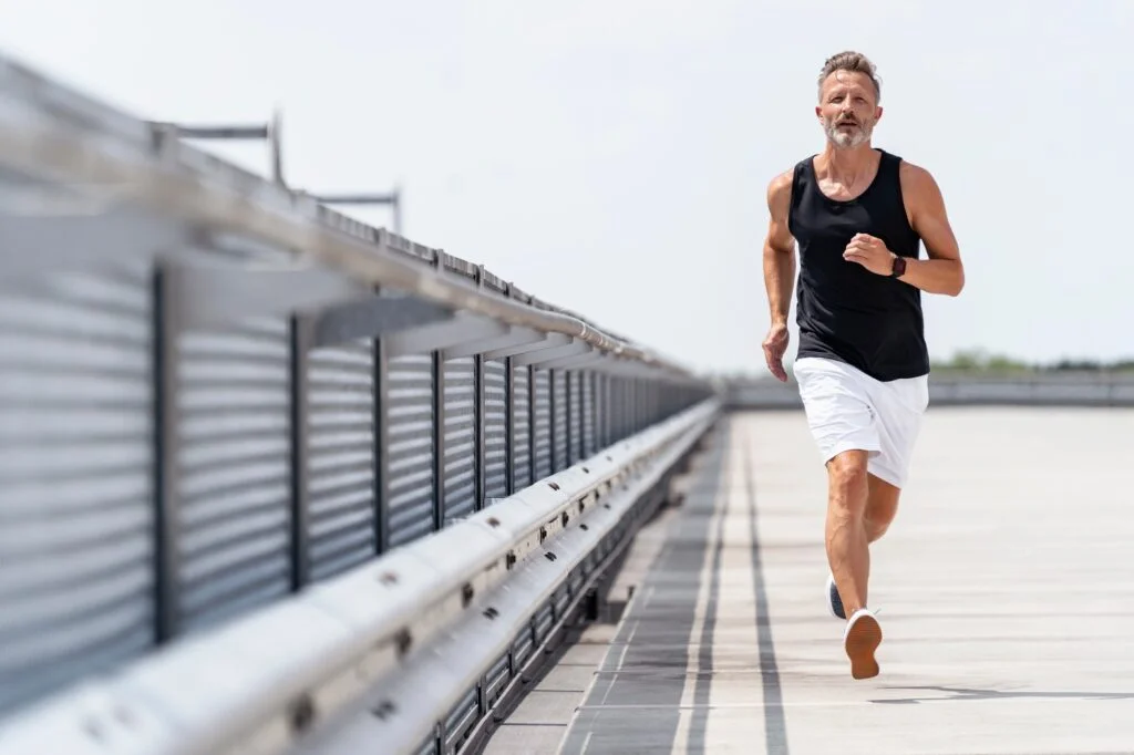 Man jogging outdoors near coastal boardwalk