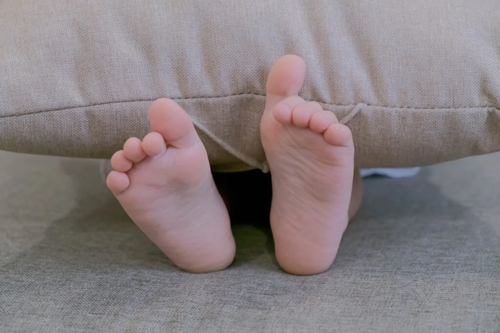 Child's feet peeking out from under blanket
