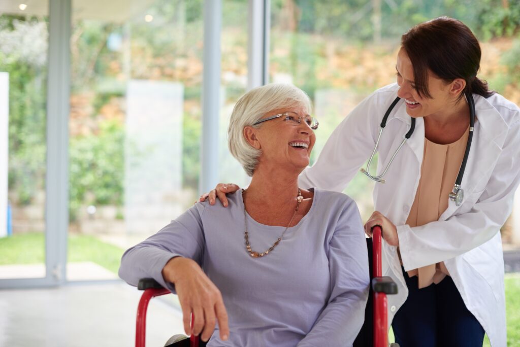 Doctor smiling with senior patient in wheelchair