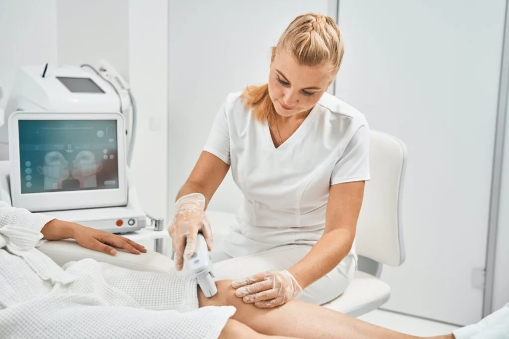 Provider using MLS laser device on patient's leg