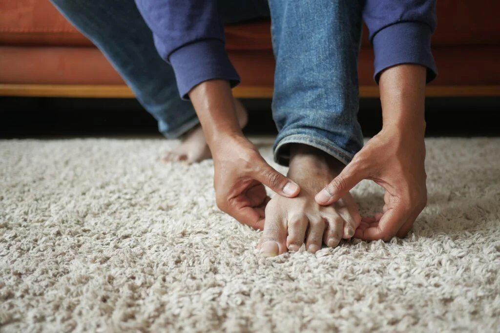 Hands examining foot during checkup