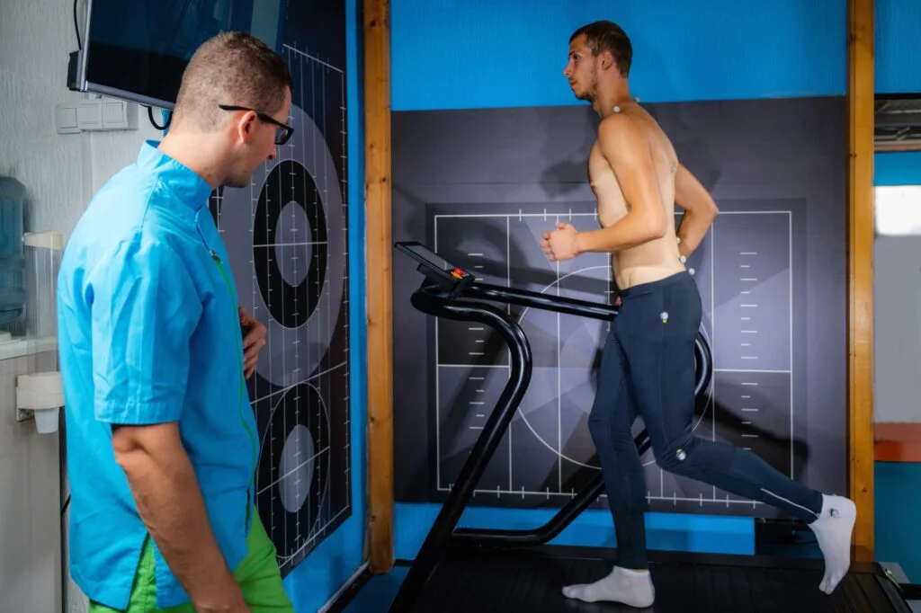 Sports medicine specialist analyzing patient's running gait on treadmill