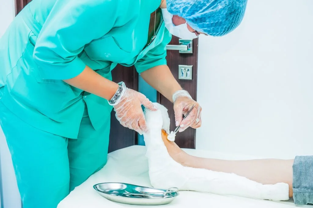 Clinician treating patient's bandaged foot wound